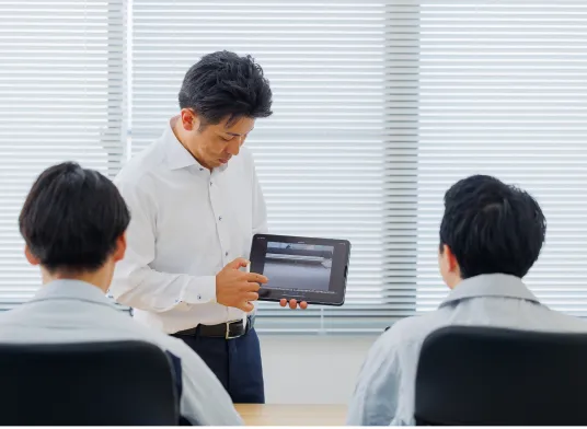 スタッフ伊藤が新人スタッフ二人に説明している写真